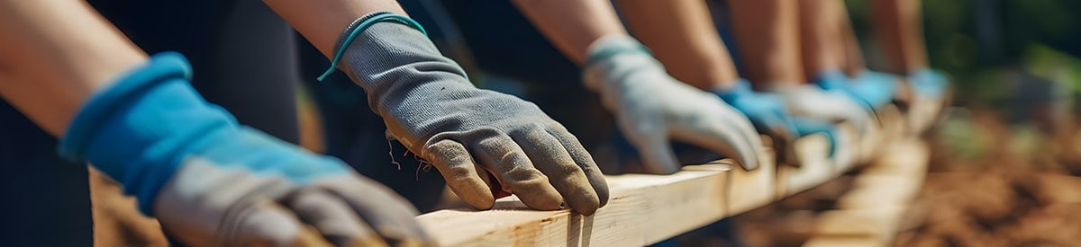 personas trabajando en un proyecto al aire libre con guantes y trabajando con madera